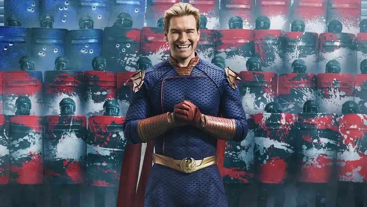 A person in a superhero costume stands confidently with gloved hands clasped, set against a backdrop of riot police with red and blue shields splattered with paint.
