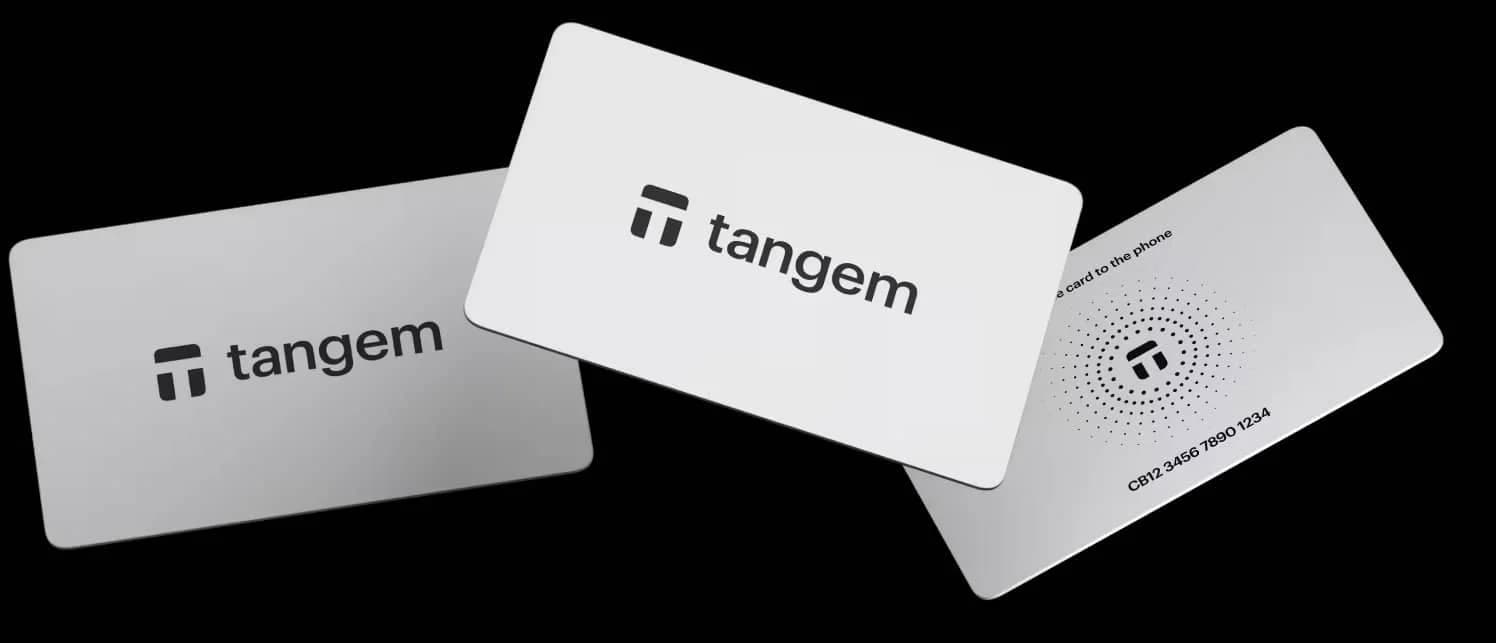Three Tangem cards displayed at different angles on a black background, featuring the Tangem logo and a serial number.