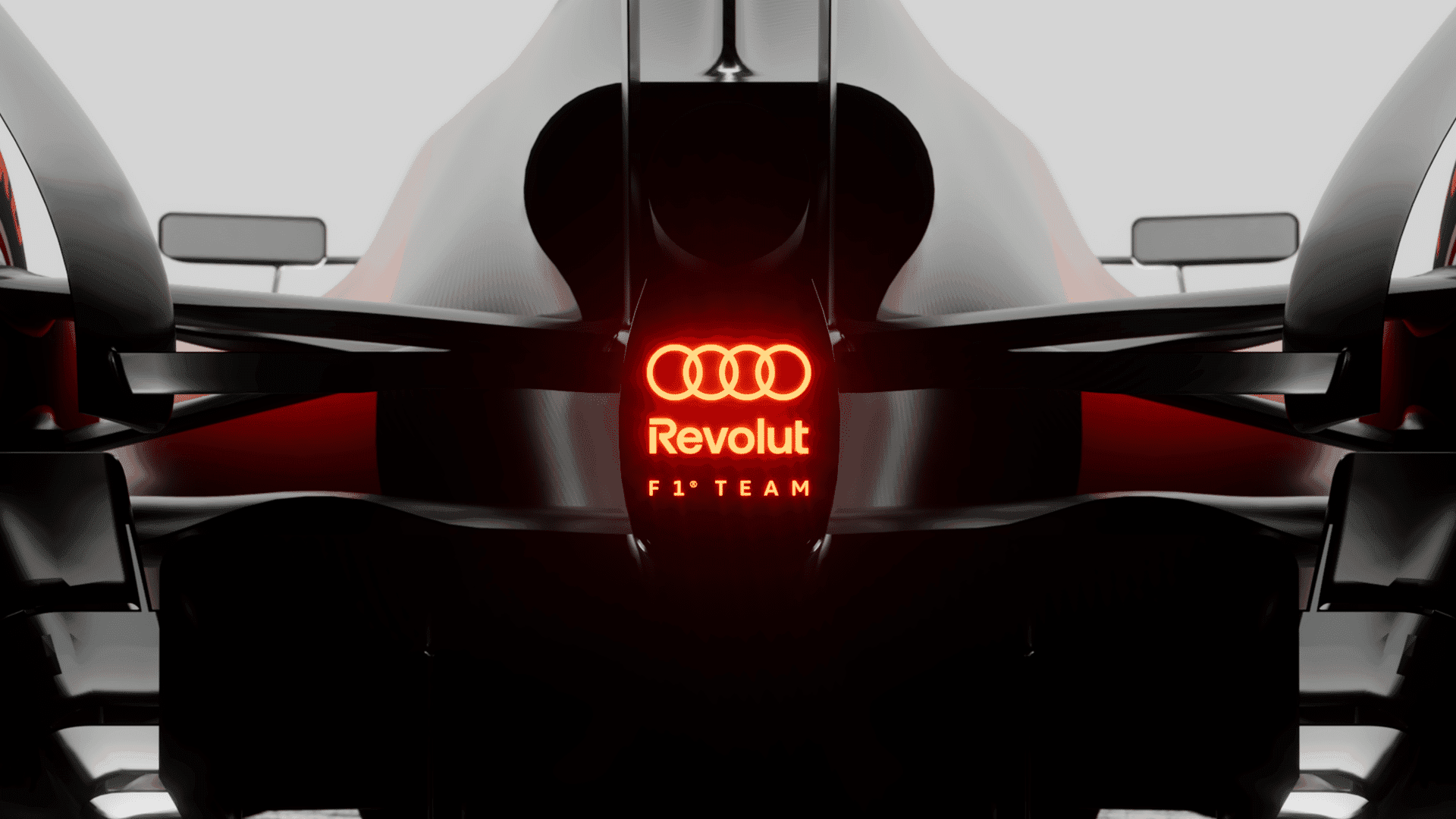 Rear view of a sleek Formula 1 car displaying the logos "Revolut" and "F1 Team" with an illuminated red logo above.
