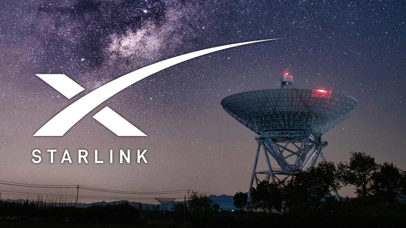 A large satellite dish under a starry night sky with the Starlink logo prominently displayed.