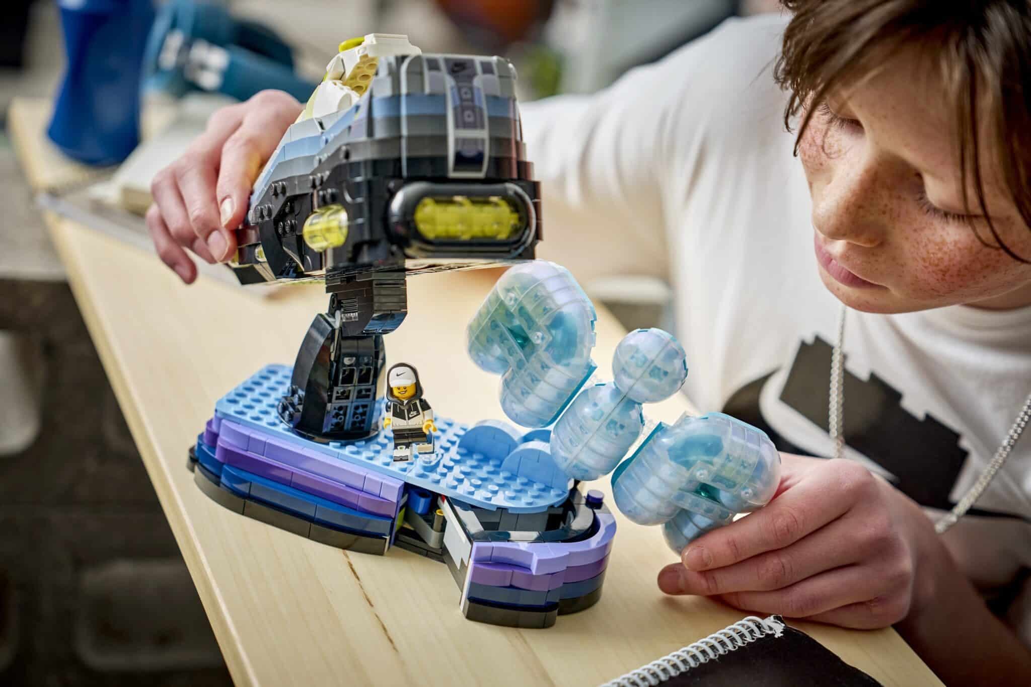 A person is playing with a space-themed LEGO set featuring a small astronaut and a large spacecraft.