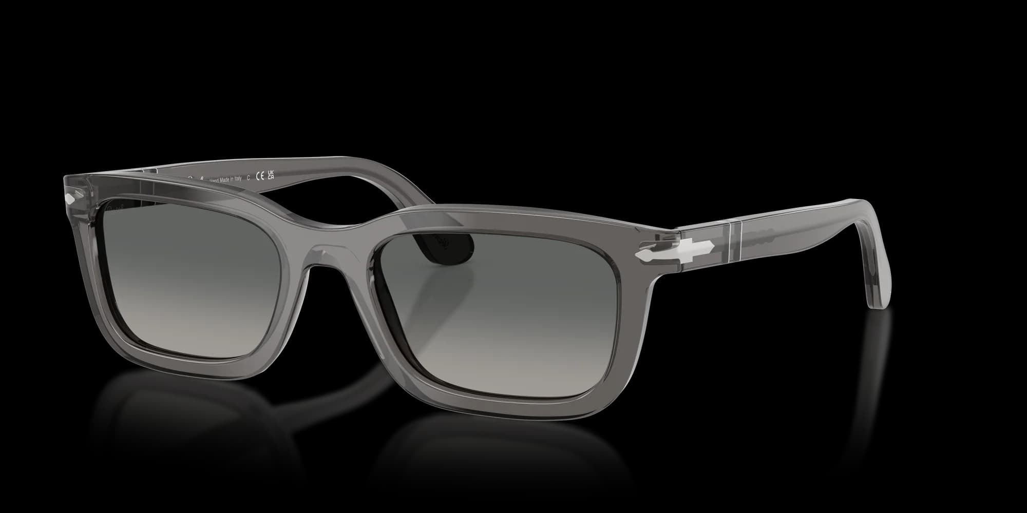 Gray translucent rectangular sunglasses with dark lenses and a glossy frame on a black background