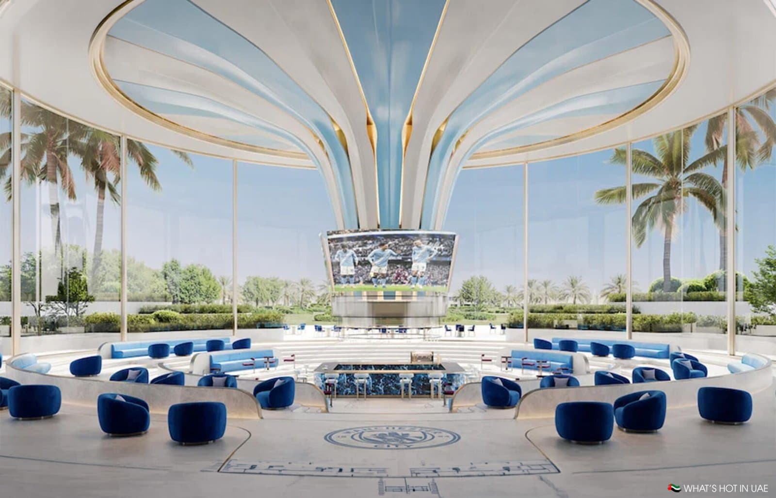 Futuristic lounge with blue seating, a giant central screen, and palm trees visible through glass walls