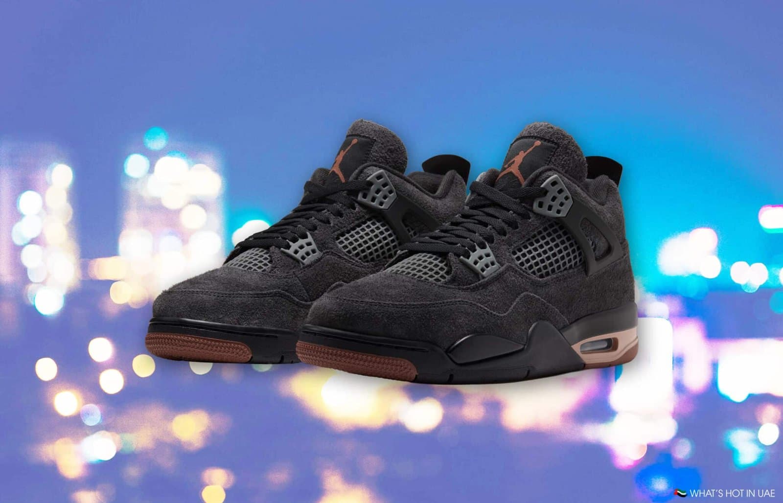 Pair of black and gray high-top sneakers with brown soles against a colorful blurred background