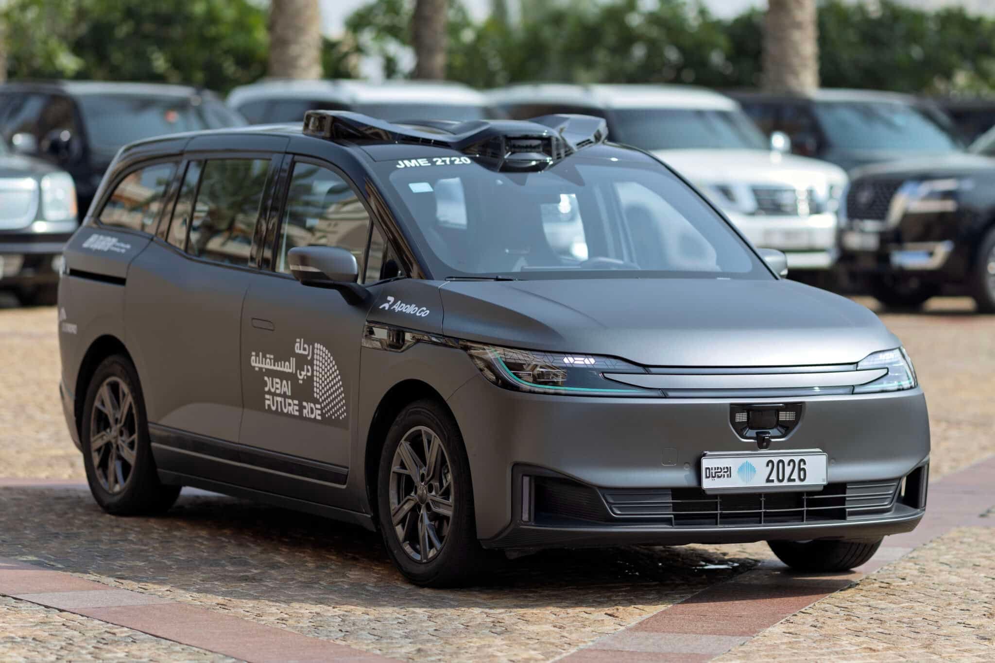 Autonomous Dubai taxi displaying “Dubai Future Ride” branding and roof-mounted sensors, with other vehicles in the background