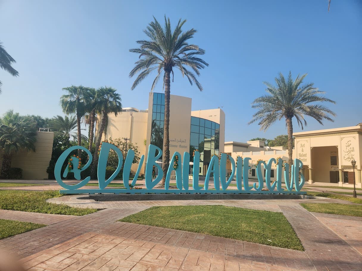 Entrance to an Art & Talent Center with a large turquoise sign, palm trees, and Arabic and English lettering
