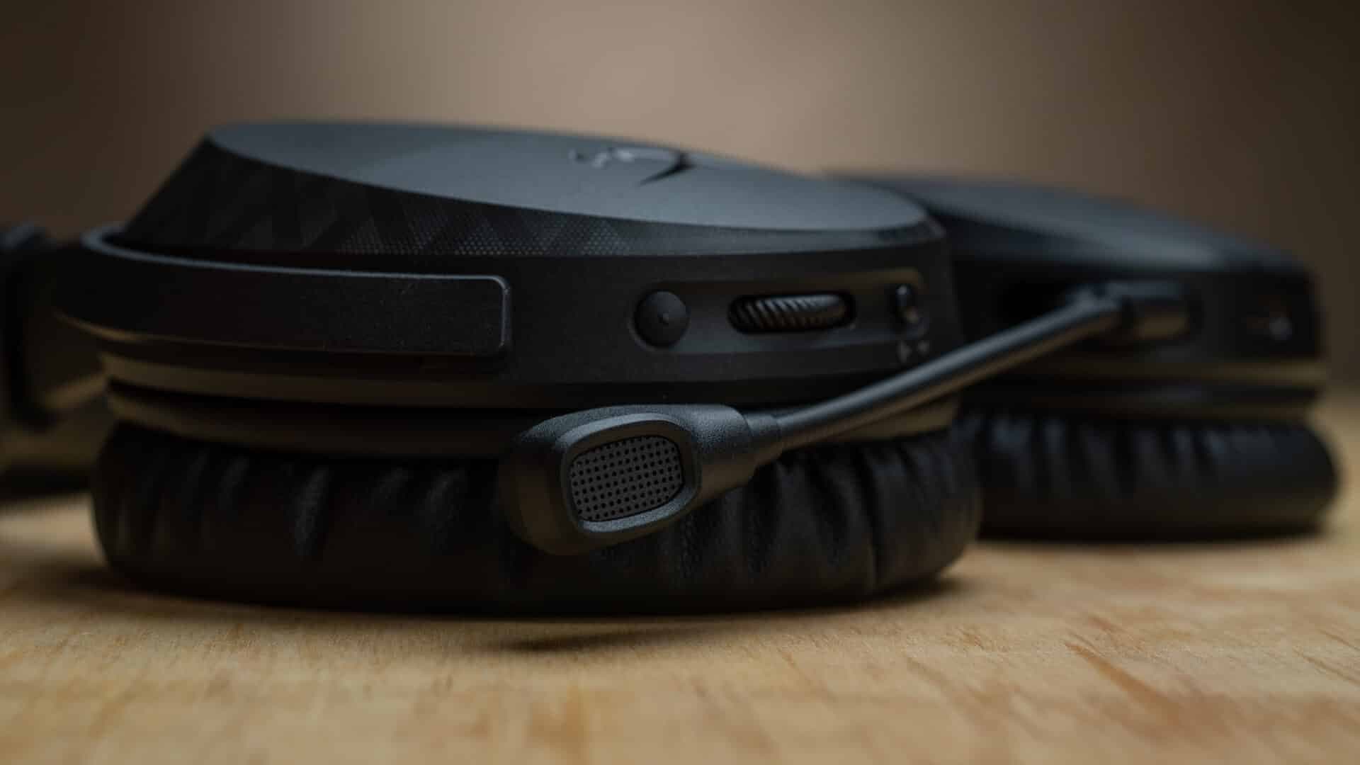 Black gaming headset with a boom microphone resting on a wooden surface