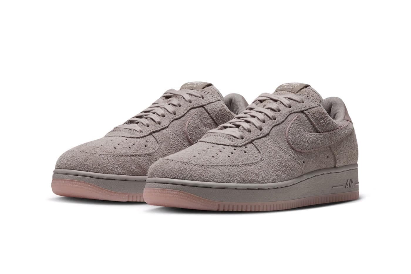 Pair of taupe Nike Air Force 1 sneakers with suede uppers and pinkish translucent soles