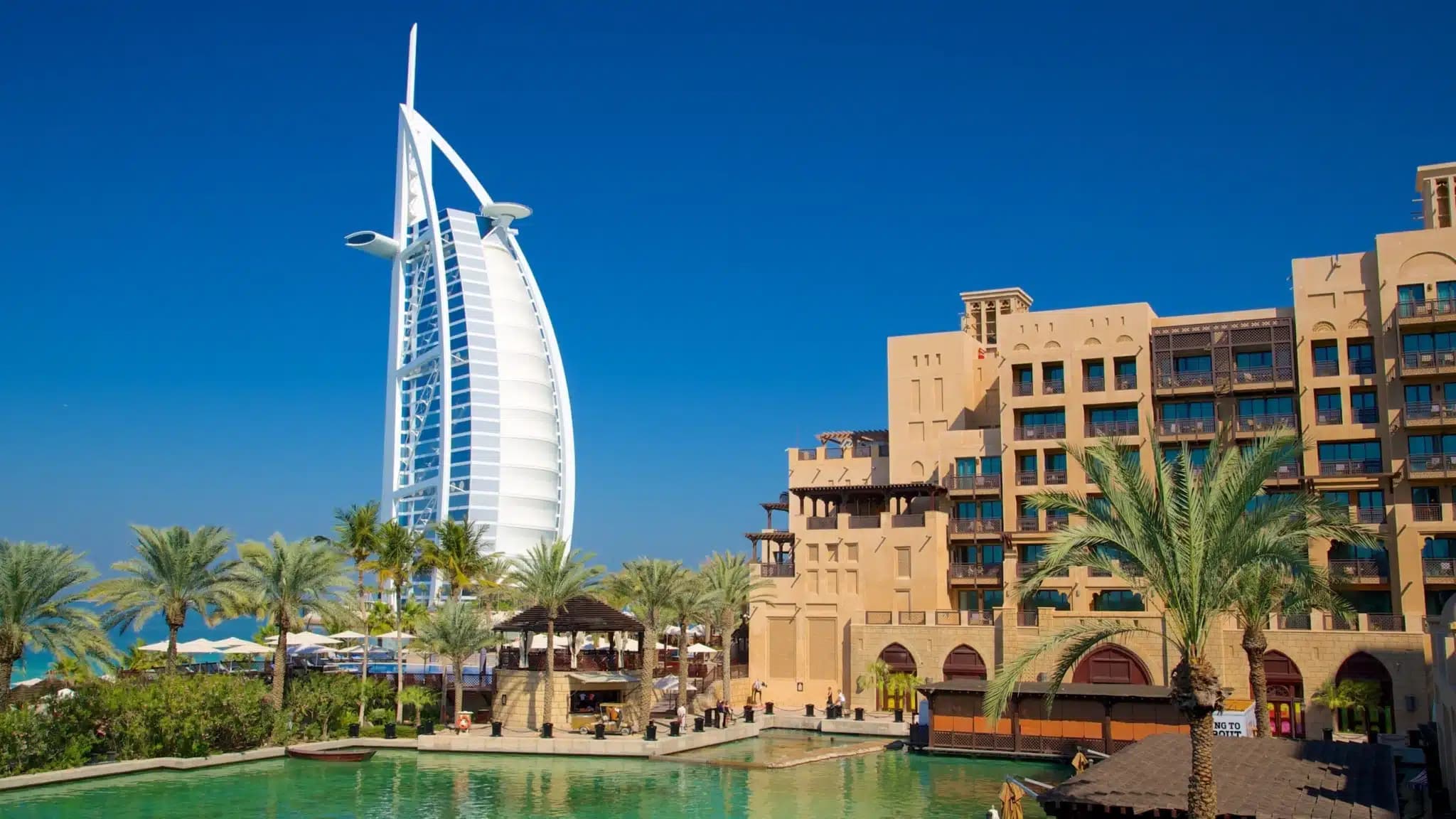 Burj Al Arab hotel overlooking a palm-lined resort and waterways in Dubai