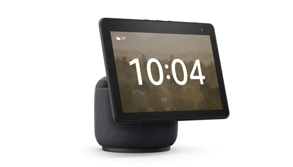 A smart display device with a touchscreen showing the time 10:04 and temperature 38°C, set on a cylindrical base with a fabric cover.