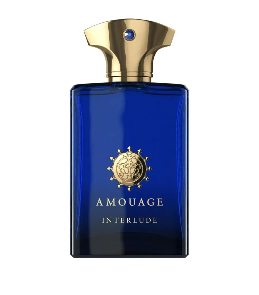 A blue bottle of Amouage Interlude perfume with a gold cap and emblem.