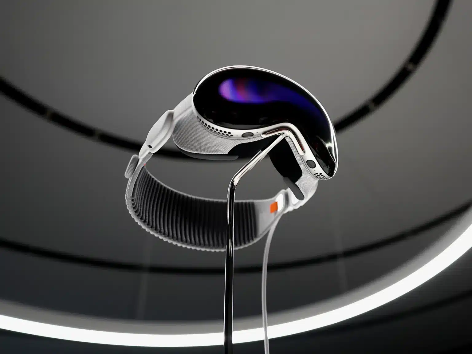 A sleek, futuristic virtual reality headset with a reflective visor, white straps, and a dark oval display, mounted on a stand with a circular ceiling light in the background.