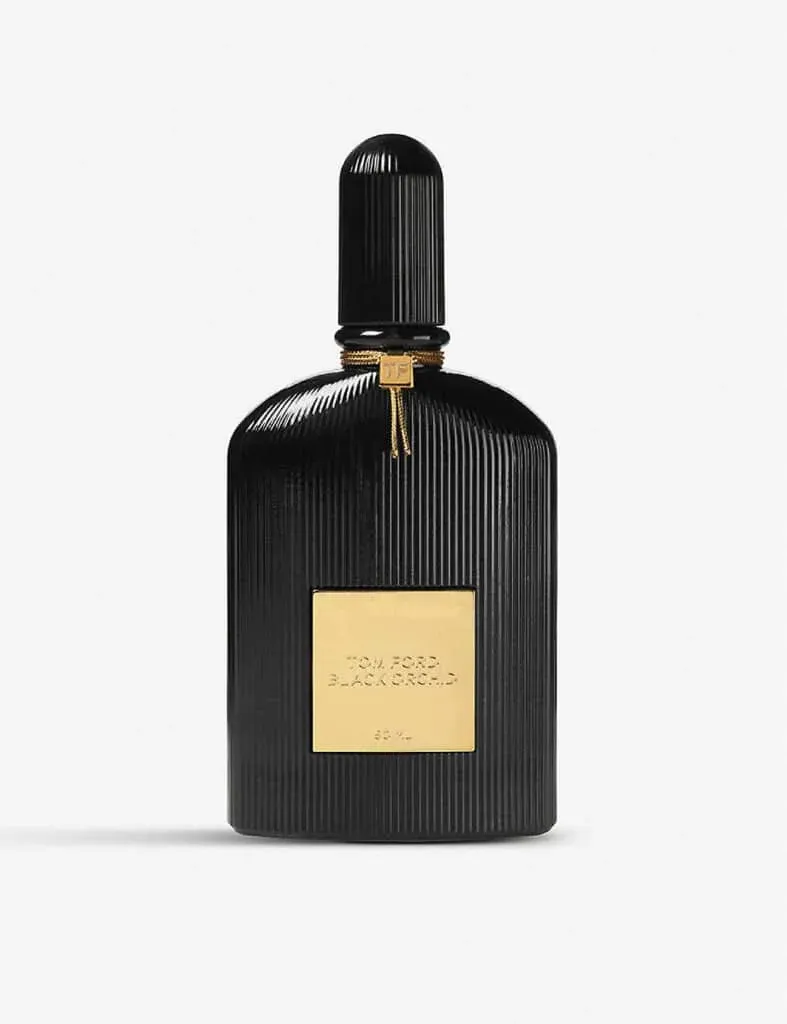 A black ribbed bottle of Tom Ford Black Orchid perfume with a gold label and a gold tag around the neck.