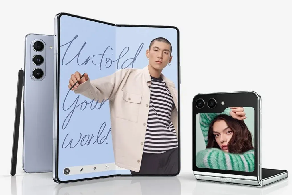 Two foldable smartphones on display: one open showing an image of a person with a striped shirt on a screen that says 'Unfold Your World,' and another half-folded showing an image of a person in a green sweater on the external screen.