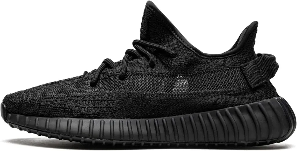 A black sneaker with a textured knit upper and a ribbed sole, featuring a low-top design and black laces.