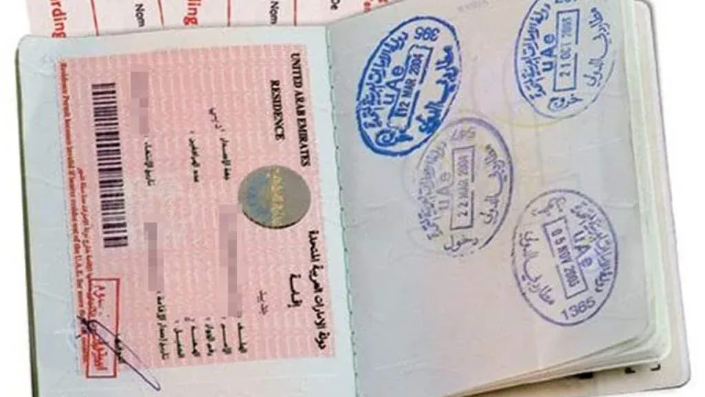 Open passport displaying a Dubai Visit Visa 2026 on one page and multiple entry stamps in blue ink on the opposite page.