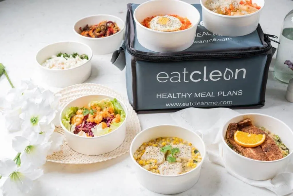 A variety of healthy meals in white bowls arranged around an
