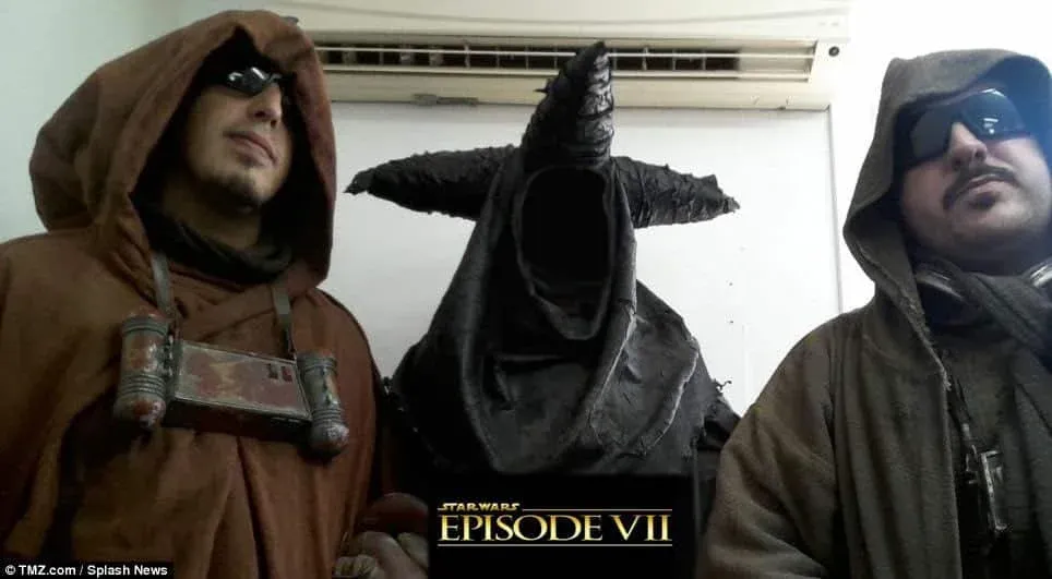 International DJs 'Smokingroove'  dressed in Star Wars-inspired costumes; two wear brown hooded robes and goggles, while the middle figure dons a black, horned cloak. The text 'STAR WARS EPISODE VII' appears at the bottom of the image. Originally published by TMZ.