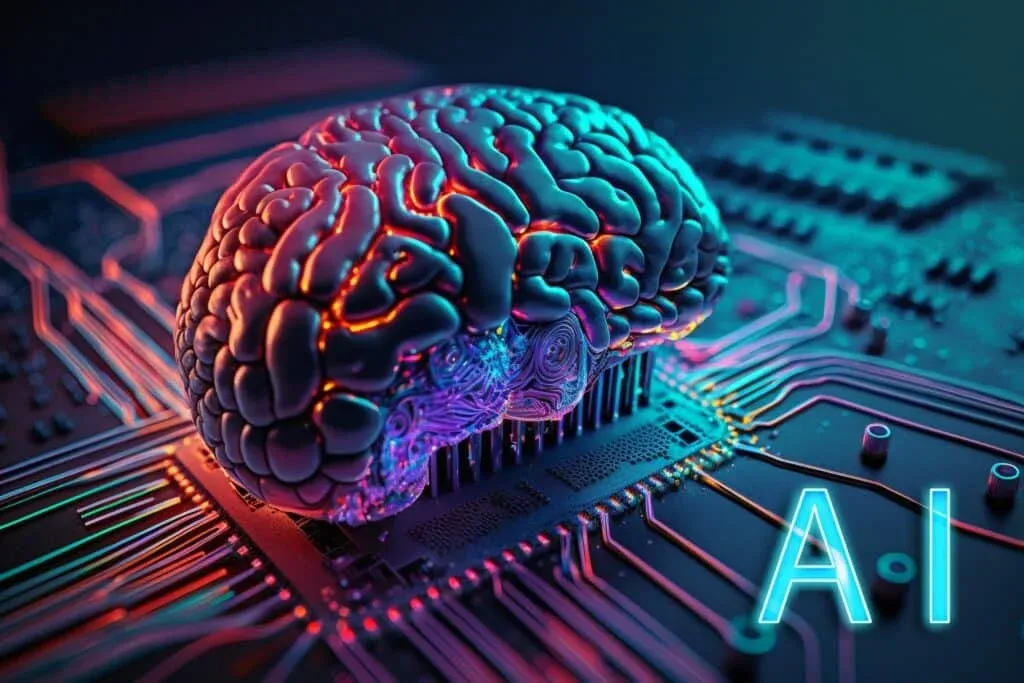 A glowing depiction of a human brain with neon colors resting on a computer circuit board, symbolizing artificial intelligence, with the letters 'AI' shown in bright blue on the right side.