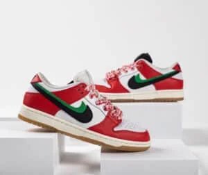 A pair of Nike sneakers displayed on white blocks. The shoes have a red, white, and green color scheme with a prominent black Nike swoosh, red and white patterned laces, and gum soles.