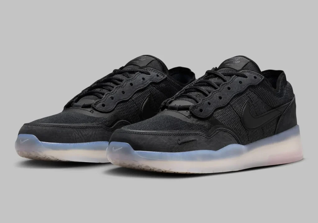 A pair of black sneakers with textured uppers and transparent rubber soles, featuring a prominent swoosh logo on the side.