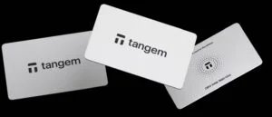 Three Tangem cards displayed at different angles on a black background, featuring the Tangem logo and a serial number.