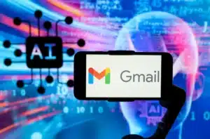 A smartphone displaying the Gmail logo against a background featuring artificial intelligence imagery, including the text 'AI' and a neural network symbol.