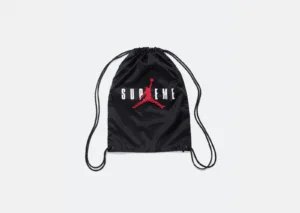 Black drawstring backpack with a red silhouette of a basketball player dunking and the word 'SUPREME' printed in white across the front.