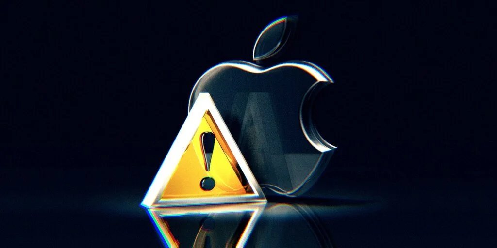 A metallic Apple logo with a yellow warning triangle featuring an exclamation mark in front of it, set against a dark background.
