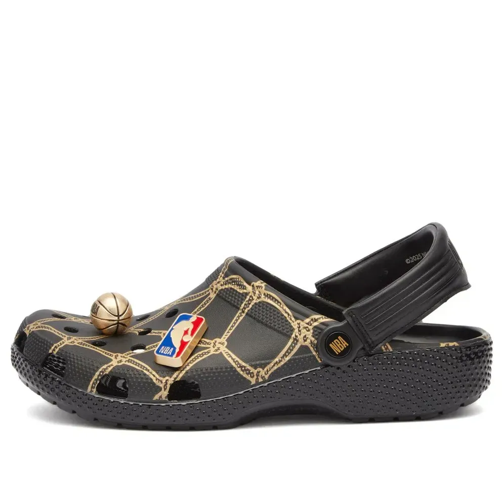 A black Crocs clog featuring a basketball net design with detachable NBA-themed charms, including a small basketball and the NBA logo.