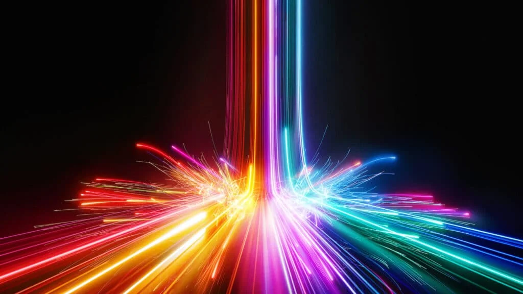 An abstract display of vibrant colored light streaks radiating from a central point, with a dark background enhancing the visual impact of the glowing lines and sparks in red, orange, purple, blue, and green shades.