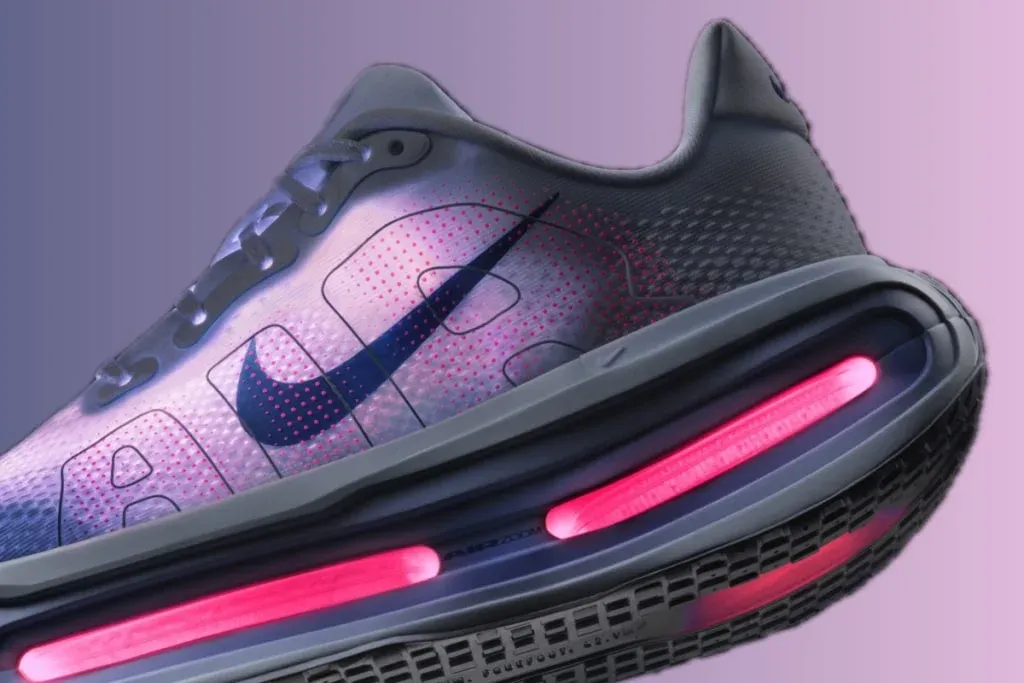 Close-up of a stylish athletic shoe featuring a sleek design, a prominent Nike logo, and a glowing pink cushioning section on the sole, set against a gradient background.