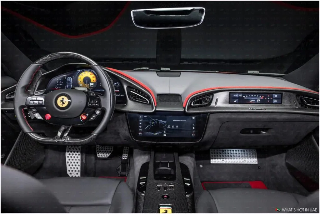 Interior view of a luxury car featuring a black and red steering wheel with the Ferrari logo, a digital dashboard display, central touchscreen controls, and sporty pedal design.