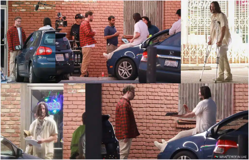 A series of images showing a film set with actors and crew members in front of a brick wall. One actor is in a white outfit, using crutches, and sitting on a blue car, while another is wearing a red plaid shirt and conversing with crew members. Equipment and a camera setup are visible in the background.