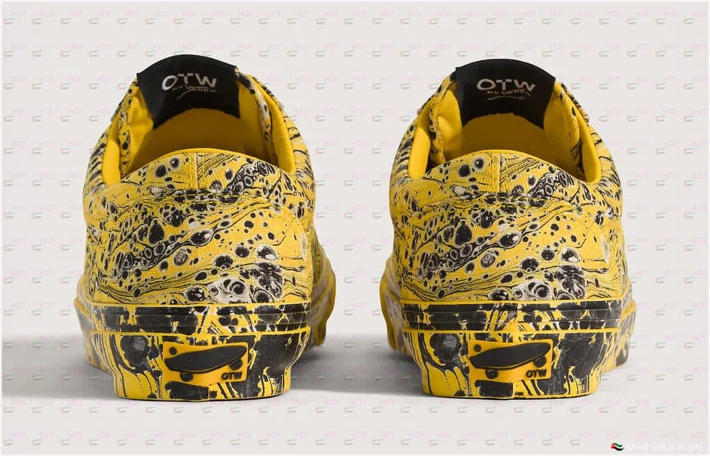 Rear view of two yellow sneakers with a black marble pattern and "OTW" branding on the heel tags, against a light background.