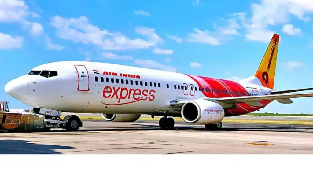 Air India Express airplane parked on the tarmac with blue skies in the background.