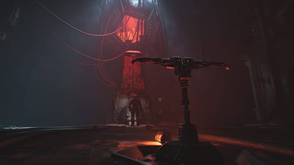 A dark, futuristic room with a large, illuminated structure emitting red light, surrounded by cables. A figure stands in front of it, backlit by the red glow, while a mechanical arm is visible in the foreground. Cronos: The New Dawn