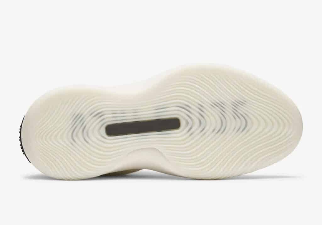 The sole of a shoe featuring a wavy, circular tread pattern with a central rectangular section visible through the transparent material.