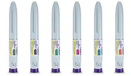 Six gray injectable pens with purple caps labeled "Mounjaro," each indicating different dosage strengths ranging from 2.5 mg to 15 mg.