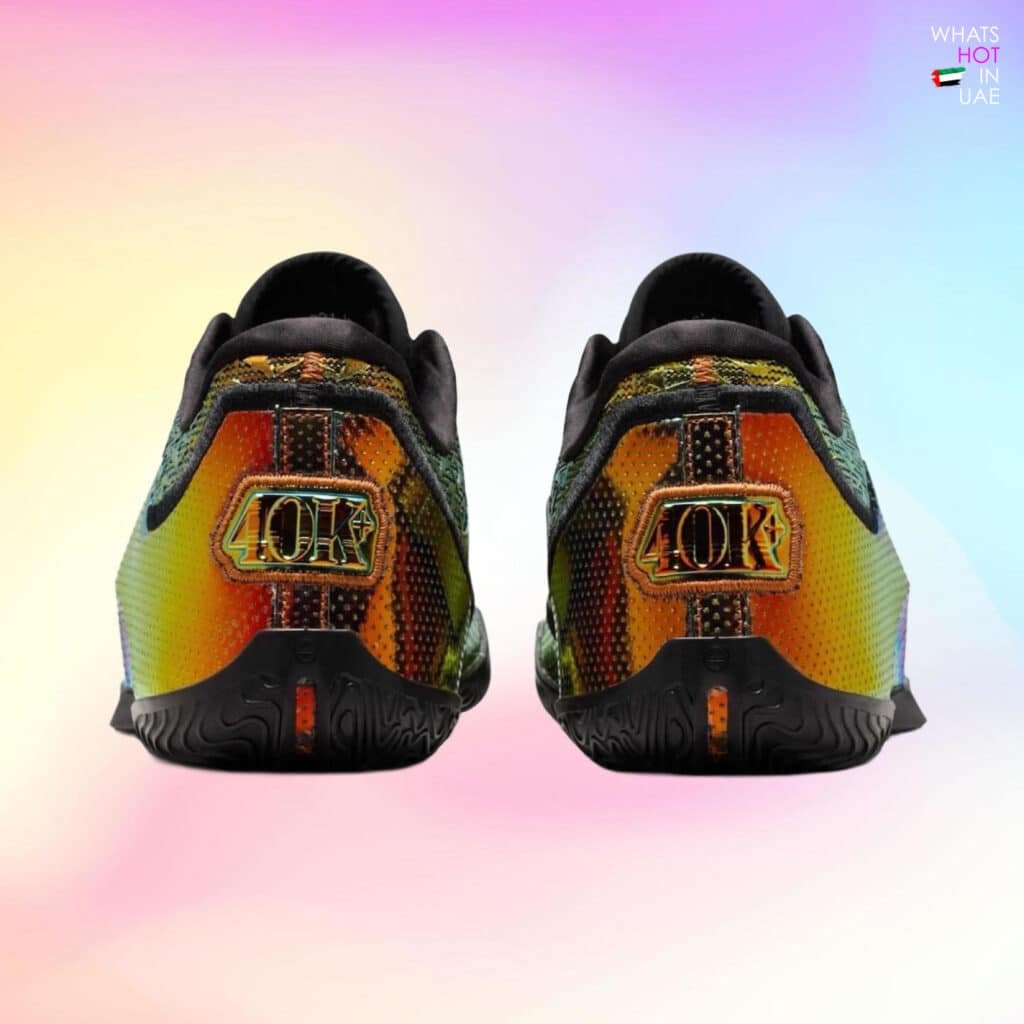 Rear view of a pair of sneakers featuring a colorful, iridescent pattern with the number '40K' prominently displayed on the heel. The background is a gradient of pastel colors. Nike LeBron 23 “40K Gold”