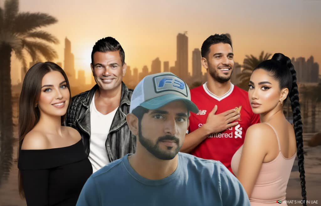 A group of five people posing in front of a city skyline and palm trees at sunset. The central figure wears a blue cap and T-shirt, surrounded by two women and two men, one in a leather jacket and another in a red sports jersey.