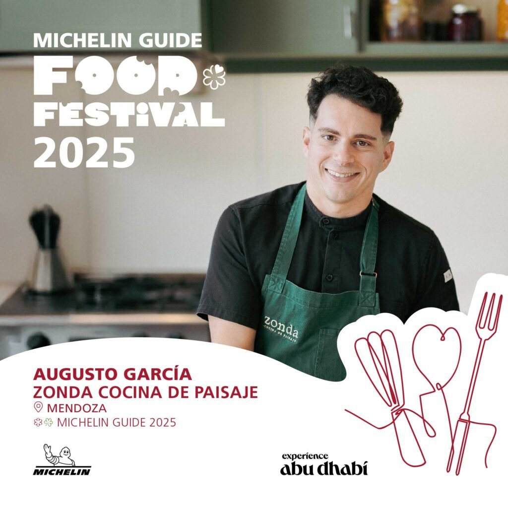 A chef in a black shirt and green apron, standing in a kitchen, featuring 'Augusto García' from 'Zonda Cocina de Paisaje' in Mendoza, sponsored by 'Experience Abu Dhabi.'