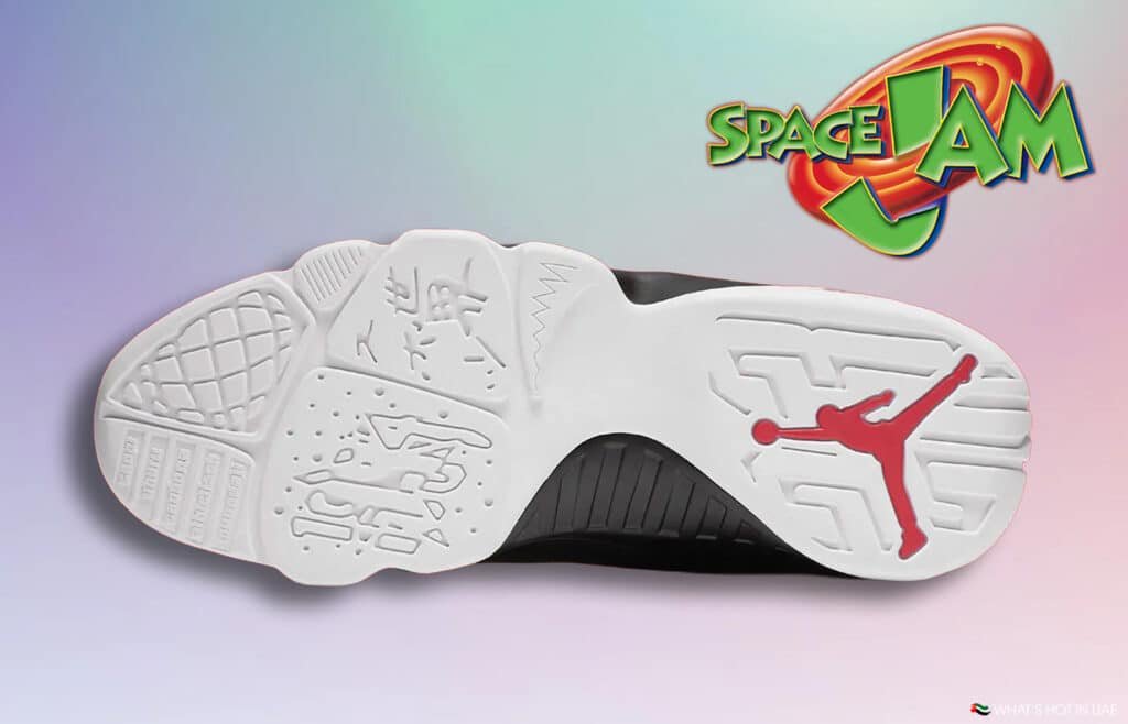 Sole of a shoe with a white base featuring intricate patterns, a red silhouette of a basketball player, and the 'Space Jam' logo in the top right corner against a gradient background.