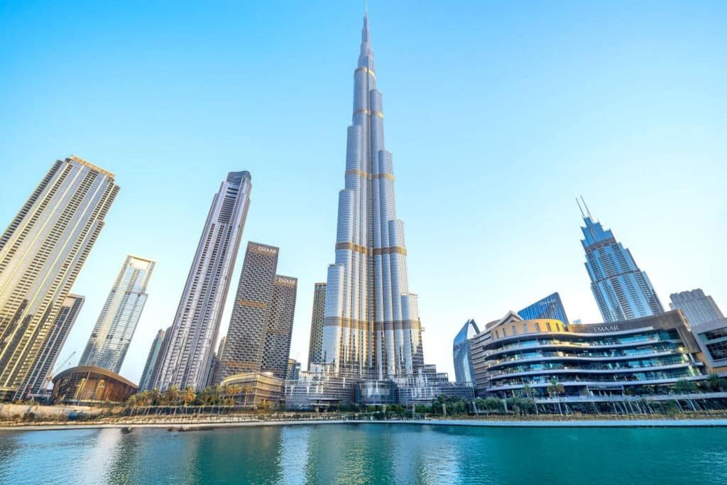 Tourist Spots in Dubai: Skyline of Dubai featuring the Burj Khalifa surrounded by modern skyscrapers and a waterfront in the foreground.