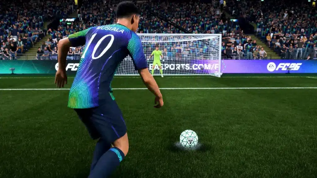 A soccer player wearing a blue and green jersey with the number 10 is about to take a penalty kick in a video game, with the goalkeeper ready in front of the goal.