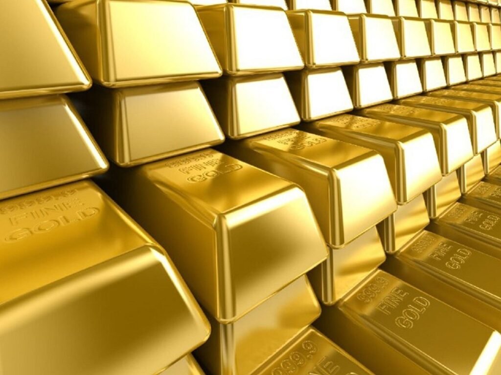 Stacks of shiny gold bars arranged closely together, each bar marked with "999.9 FINE GOLD."