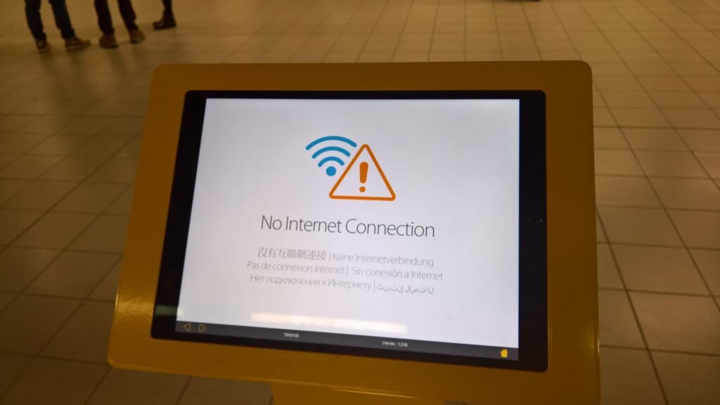 huge internet outage: A screen displaying a 'No Internet Connection' message with a warning triangle icon, set in a public place with tiled flooring.