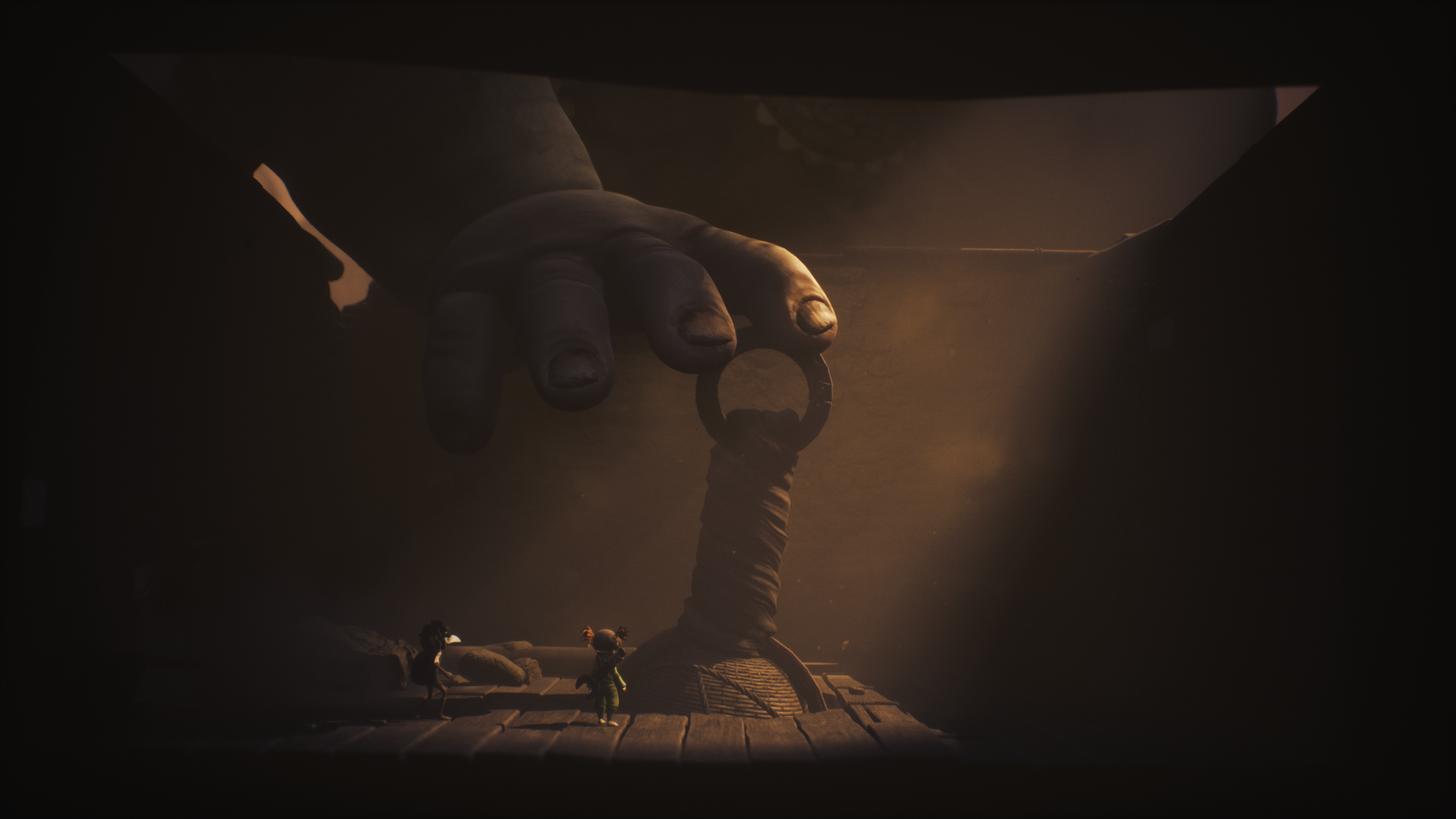 A dramatic scene depicting a giant hand reaching towards two small characters standing on a wooden platform, with moody lighting creating a tense atmosphere.