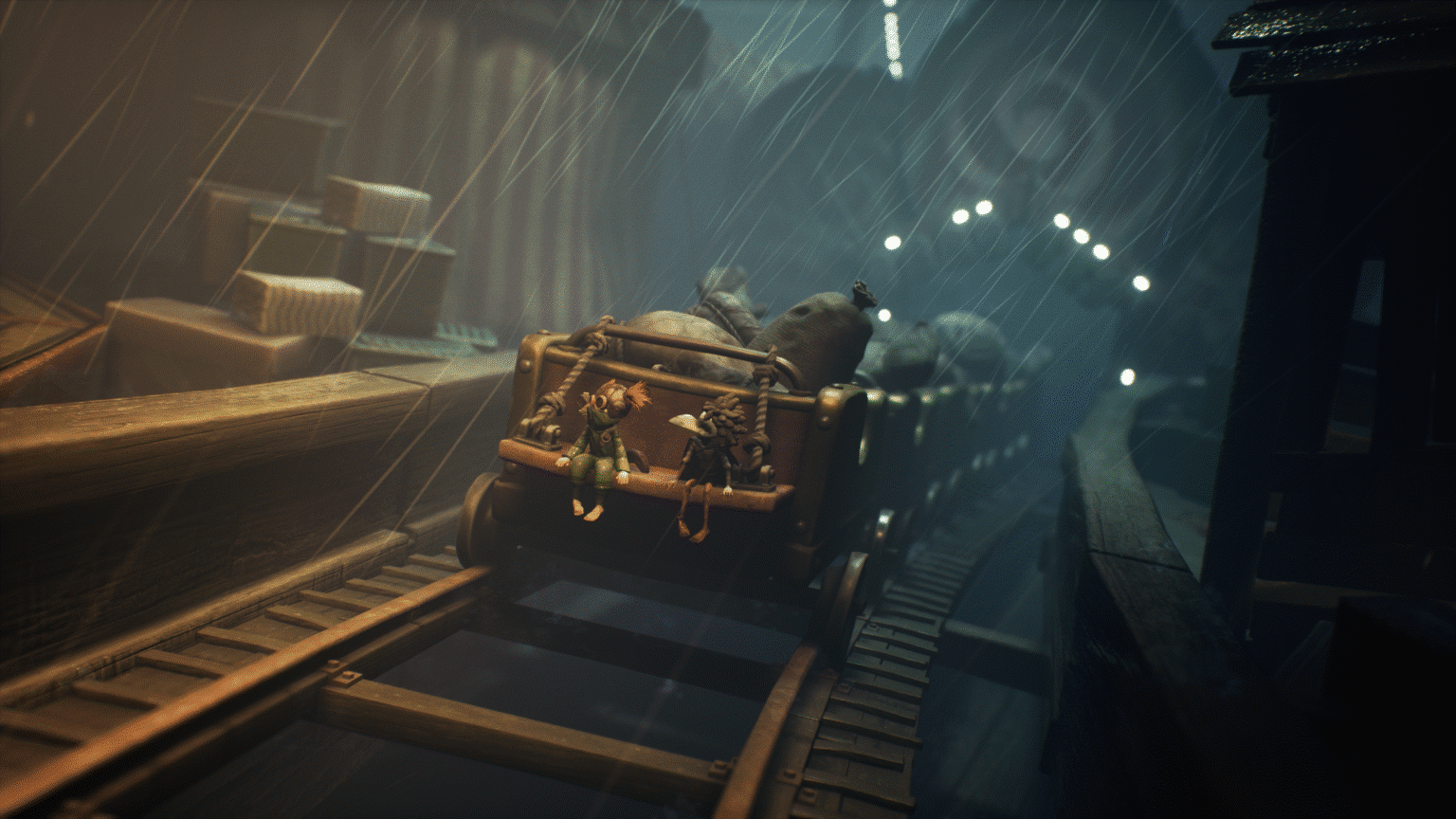 Two animated characters sitting on an open train cart, surrounded by large sacks, on a roller coaster-like track in a rainy and dimly lit environment.