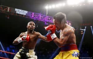 Two boxers engage in a match under bright arena lights, with one punching the other. A large sign above the ring displays their names, "Mayweather Pacquiao."